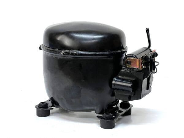 A black air compressor sitting on top of a white floor.