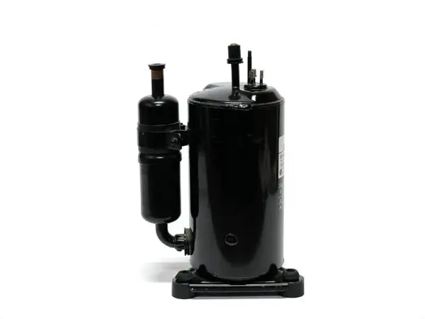 A black air compressor on top of a white wall.