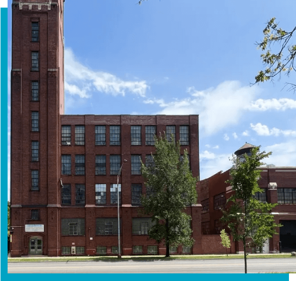 A large brick building with trees in front of it.