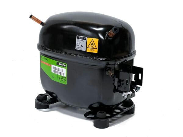 A black compressor is sitting on top of the ground.