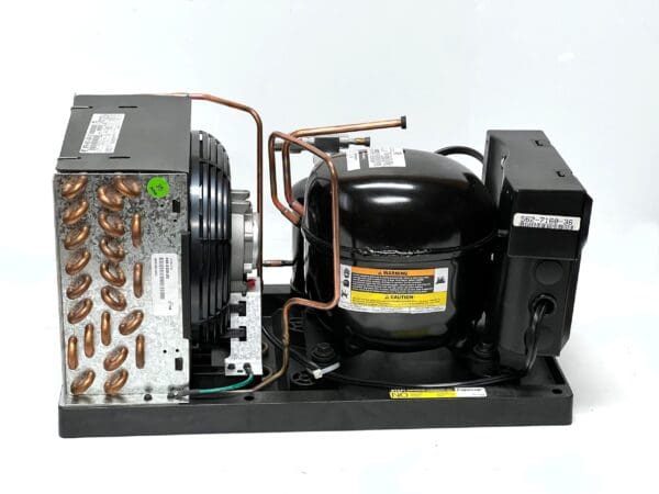 A compressor is connected to the unit and has many copper wires.