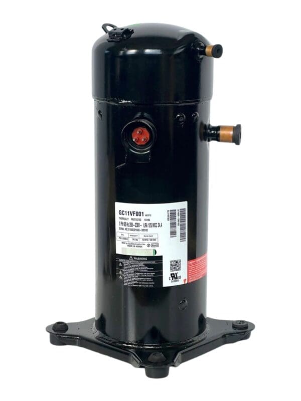 A black compressor is sitting on the ground.