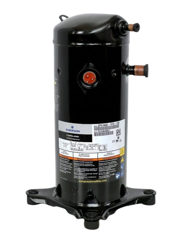 A black compressor is sitting on top of the ground.